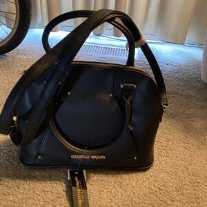 Black handbag with crossbody handles and hand straps.